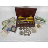 A wooden box containing a quantity of coins and banknotes,