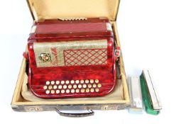 A vintage Scandalli accordion contained in carry case and a Hohner harmonica and one other.