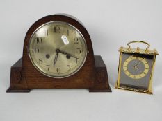 An oak cased mantel clock with carved de