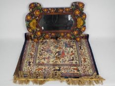 A wood framed wall mirror with floral de