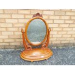 A wood framed, swing, toilet mirror, app