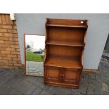 Ercol - A Waterfall bookcase with lower twin door cupboard section,