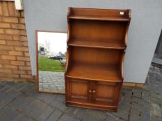 Ercol - A Waterfall bookcase with lower twin door cupboard section,