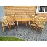 Ercol - An extending dining table with ten Goldsmith chairs,