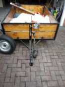 An open-topped trailer with a hand winch, rear support stands, jockey wheel and spare tyre.