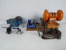 A mixed lot of workshop tools to include a bench grinder two bench vices and an "Eclipse" push