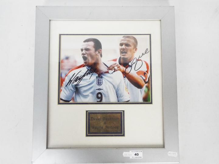 A signed photograph of Wayne Rooney and David Beckham, mounted and framed in glazed display,