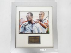 A signed photograph of Wayne Rooney and David Beckham, mounted and framed in glazed display,