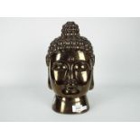 An Asian, bronzed ceramic Buddha head, approximately 30 cm (h).