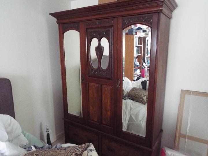 A late 19th C / early 20th C gentleman's mahogany wardrobe with mirrored doors,