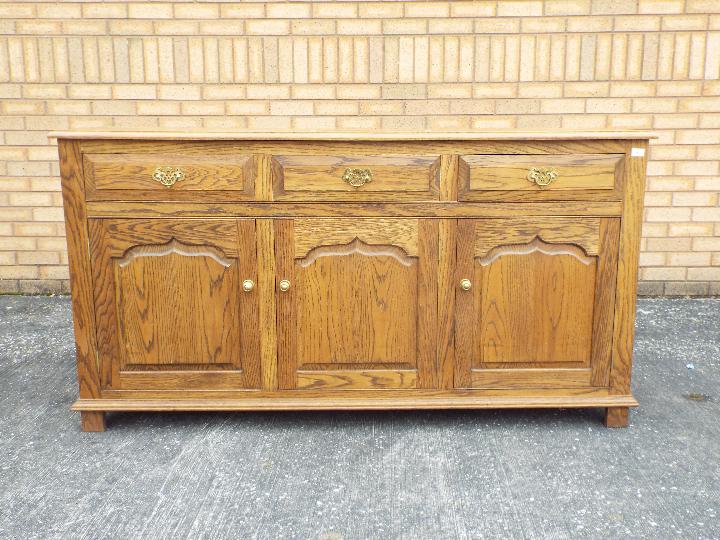 A sideboard with three short drawers ove
