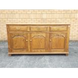 A sideboard with three short drawers ove