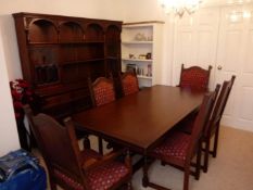 An extending dining table with four dining chairs and two carvers with upholstered seats,