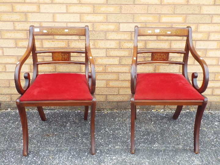 A pair of mahogany armchairs with inlaid decoration.