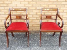 A pair of mahogany armchairs with inlaid decoration.