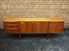 A H McIntosh - A mid century teak sideboard having central twin door cupboard flanked to one side