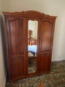 A triple wardrobe with external mirror to central door,