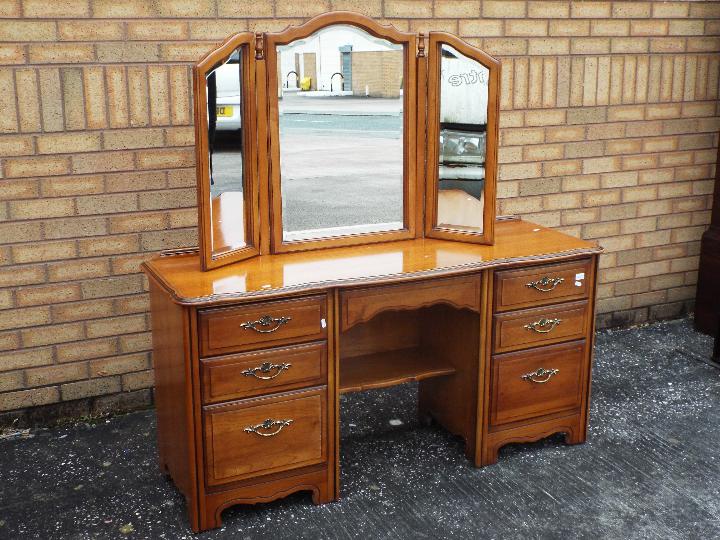 A kneehole dressing table with triptych mirror and six drawers,