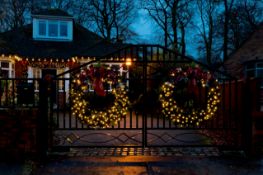 A 3 foot green frosty wreath illuminated with warm white lights and plug.