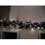 A double 9 foot green garland illuminated with ice white lights and plugs.