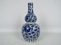 A blue and white double gourd vase with foliate decoration, approximately 27 cm (h),