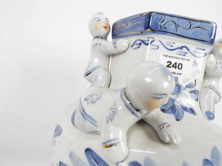 A large blue and white vase with floral decoration and applied figures of climbing boys, - Image 5 of 7