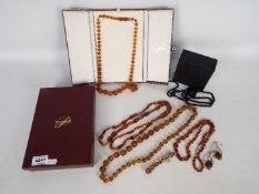 A graduated amber bead necklace, contained in presentation box, approximately 66 cm (l),