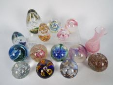 A varied collection of paperweights including Caithness and a Caithness vase.