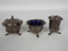 A George V three piece condiment set comprising mustard pot with blue glass liner,