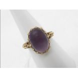 A 9ct gold ring set with cabochon purple stone, size M½, approximately 5.