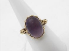 A 9ct gold ring set with cabochon purple stone, size M½, approximately 5.