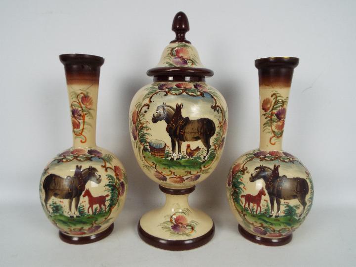 A garniture of three hand painted glass vases comprising ovoid pedestal vase with cover,
