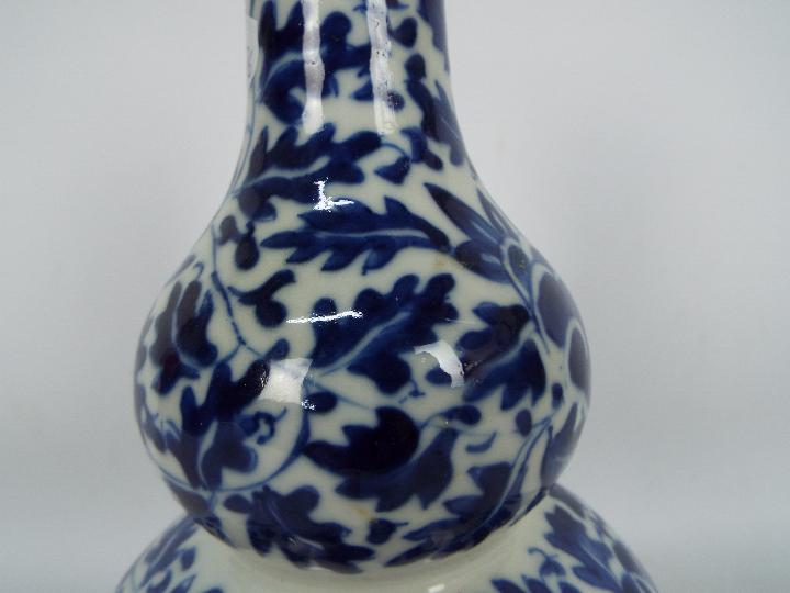 A blue and white double gourd vase with foliate decoration, approximately 27 cm (h), - Image 5 of 9