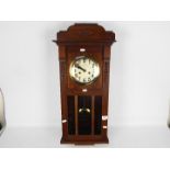 Wood cased wall clock with key and pendulum.