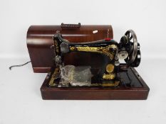 A vintage Singer sewing machine contained in carry case.