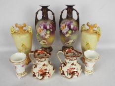 A pair of twin handled vases with floral decoration, a pair of tapered vases with floral decoration,