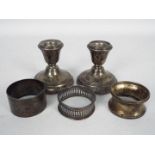 A pair of silver dwarf candlesticks on circular form loaded bases,