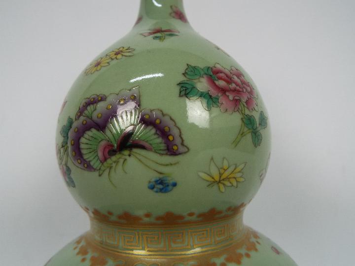 A Chinese double gourd vase decorated with flowers and butterflies against a green ground, - Image 10 of 18
