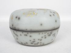 Tim Andrews - An earthenware raku dish and cover in pale blue / grey,