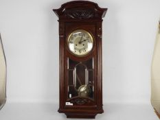A mahogany cased wall clock, the case with carved decoration and astragal glazing,
