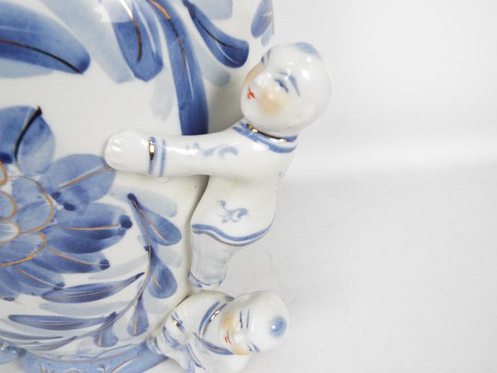 A large blue and white vase with floral decoration and applied figures of climbing boys, - Image 3 of 7