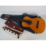 Vintage acoustic guitar in carry case and a Hohner Melodica Piano 27 in case.