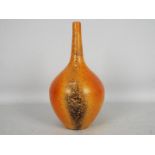 John Nuttgens - A 20th century bottle vase in a vibrant orange colour with black speckling,