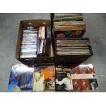 A collection of 12" vinyl records and a quantity of DVD's.