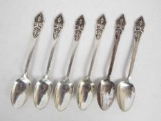 A set of six white metal coffee spoons with Buddha terminals, stamped Sterling Made In Siam,