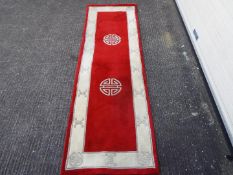 A Chinese wool carpet measuring approximately 240 cm x 76 cm