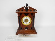 An oak cased mantel clock by Fattorini & Sons, Bradford, with key and pendulum,