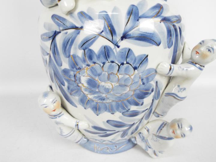 A large blue and white vase with floral decoration and applied figures of climbing boys, - Image 2 of 7