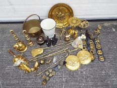 A collection of metalware, predominantly brass to include safety lamp, horse brasses and similar.