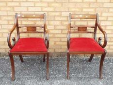 A pair of mahogany armchairs with inlaid decoration.